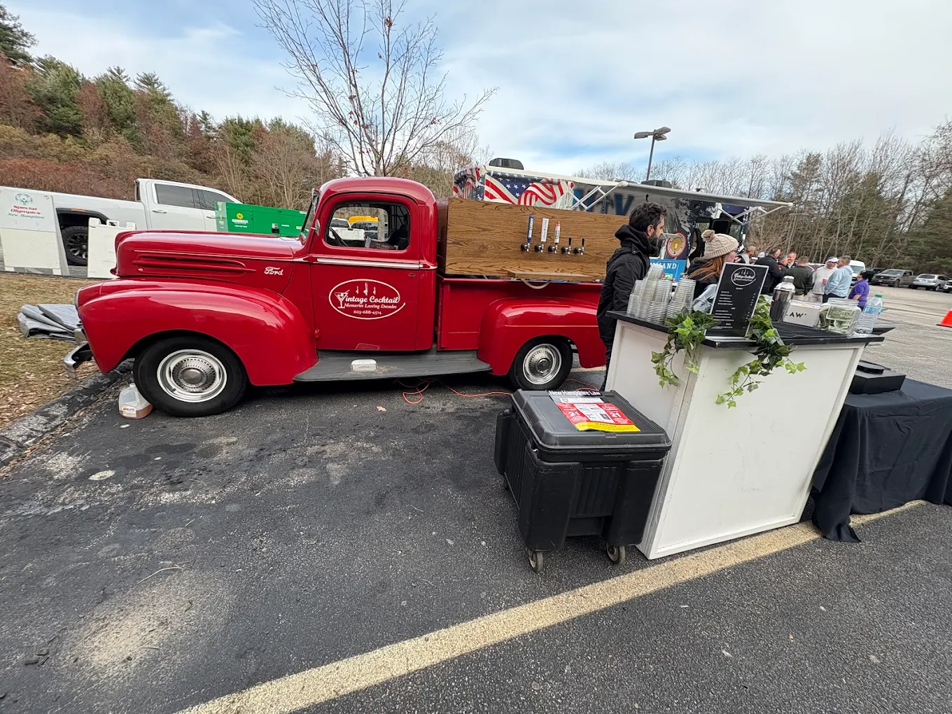 Vintage red Ford tap truck at outdoor corporate event with satellite bar